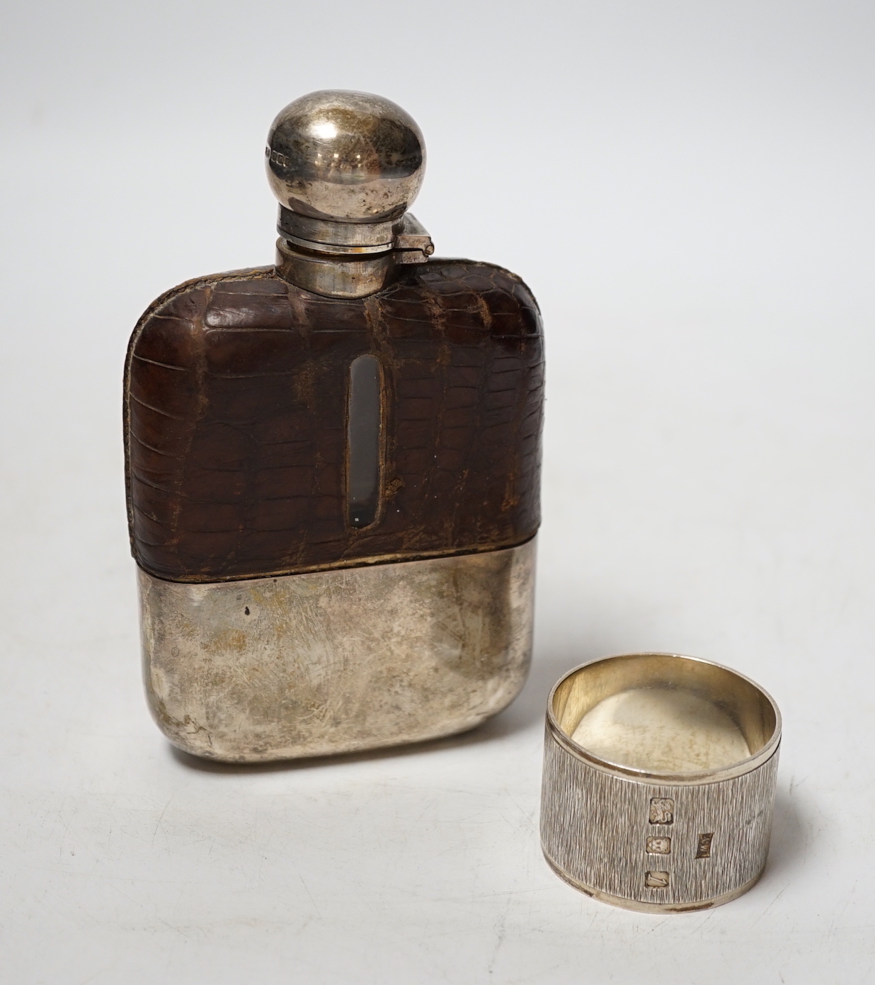 A late Victorian silver and crocodile skin mounted glass hip flask, James Dixon & Sons Ltd, Sheffield, 1899, 14cm, together with a modern silver napkin ring by Mappin & Webb.